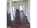 A spacious living room boasts dark wood floors, a fireplace, and plenty of natural light from windows and a glass door at 114 Revere Turn, Fairburn, GA 30213