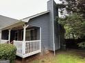 Rear exterior view of the home showcasing a white porch with mature landscaping at 525 Brooksdale Dr, Woodstock, GA 30189