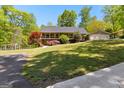 Lovely ranch-style home featuring a spacious lawn, mature landscaping, and a welcoming front porch at 335 Winding Stream Trl, Hampton, GA 30228