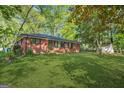 Well-maintained red brick home with a lush green lawn and mature trees surrounding the property at 172 W Campbellton St, Fairburn, GA 30213