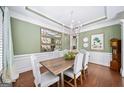 Elegant dining room with tray ceiling, chandelier, and wainscoting, perfect for entertaining at 2358 New Salem Trce, Marietta, GA 30064