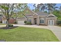 Elegant brick home with a manicured lawn and a spacious driveway leading to an attached garage at 1619 Cascade Overlook, Peachtree City, GA 30269