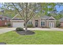 Beautiful brick home with a well-maintained lawn, mature landscaping, and inviting double door entrance at 1619 Cascade Overlook, Peachtree City, GA 30269