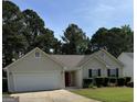 Inviting single-Gathering home with a two-car garage, a red door, and manicured front yard at 12214 Cypress Way, Fayetteville, GA 30215