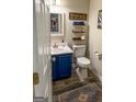Charming half bathroom with a blue vanity and a decorative rug at 345 S Magnolia Se Walk, Atlanta, GA 30349