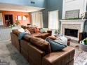 Cozy living room featuring a brick fireplace, comfortable brown sectional, and views to the kitchen area at 345 S Magnolia Se Walk, Atlanta, GA 30349