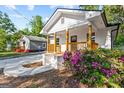 Lovely home with a charming front porch, featuring natural wood railing and beautiful flowering shrubs at 849 Wood Nw St, Atlanta, GA 30318