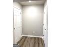 Hallway with fresh paint, laminate flooring, base trim and multiple doors at 1605 Hydrangea Ln, Mcdonough, GA 30253