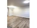Spacious living room area with laminate flooring, fresh paint and modern light fixture at 1605 Hydrangea Ln, Mcdonough, GA 30253