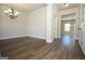 Inviting living room with neutral walls, stylish chandelier, and wood flooring perfect for relaxation at 305 Wheeler Creek Ln # 21, Mcdonough, GA 30252