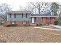 Charming split-level home with brick and siding exterior, complemented by red shutters and a well-kept lawn at 77 Crystal River Dr, Riverdale, GA 30274