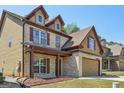 Brick home featuring an attached 2 car garage, covered porch, and well manicured lawn at 2638 Lake Manor Cir, Duluth, GA 30096