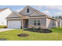 Charming single-Gathering home featuring a two-car garage and professionally landscaped front yard at 289 Limestone Circle, Conyers, GA 30013