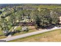 Expansive aerial view of the property with a long driveway and abundant trees at 1092 E Lake Rd, Mcdonough, GA 30252
