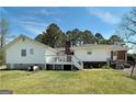 Back exterior showcasing the deck, chimney and the spacious backyard at 1092 E Lake Rd, Mcdonough, GA 30252