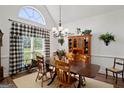 Traditional dining room with large window, chandelier, and wooden table and chairs at 1108 Sequoia Trl, Mcdonough, GA 30252