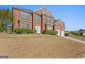 A two-story red brick house with an attached garage and well-maintained lawn at 3971 Busby Mill Ct, Ellenwood, GA 30294
