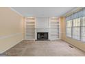 Inviting living room featuring a fireplace, built-in bookshelves, and natural light from a nearby window at 9276 Fieldstone Ct, Jonesboro, GA 30236