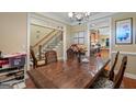 Inviting dining room featuring a wood table, staircase view, and access to the kitchen at 1154 Ridge Hollow Ln, Lawrenceville, GA 30043