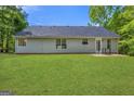 View of back exterior with expansive green lawn and grey siding at 1012 Miss Amber Way, Locust Grove, GA 30248