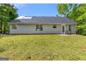 The home features a large backyard with a well-maintained lawn and exterior clad in light grey siding at 1012 Miss Amber Way, Locust Grove, GA 30248