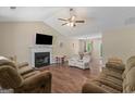 Inviting living room with vaulted ceiling, fireplace, ceiling fan, and an open view into the adjacent dining area at 1012 Miss Amber Way, Locust Grove, GA 30248