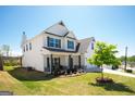 Exterior side view of a two-story white home with well-kept lawn and blue skies at 44 Mediterranean Ave, Sharpsburg, GA 30277