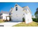 Two car garage of a charming two-story white home and lush green lawn at 44 Mediterranean Ave, Sharpsburg, GA 30277