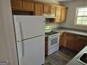 Functional kitchen featuring wood cabinets, a white refrigerator, and standard white appliances at 2039 Faith Cv, College Park, GA 30349