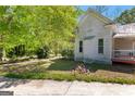 Exterior view of classic home with side porch, showcasing the yard and architectural charm at 2354 Hamilton St, Hampton, GA 30228