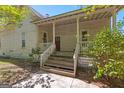Inviting covered front porch with wooden steps and railing, perfect for relaxing outdoors at 2354 Hamilton St, Hampton, GA 30228