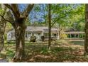 Quaint single-story home with a carport surrounded by mature trees and a leafy yard at 395 Hood Ave, Fayetteville, GA 30214