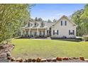 Inviting two-story home with a spacious front porch, well-manicured lawn, and charming curb appeal at 49 Moss Cts, Palmetto, GA 30268
