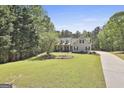 A beautiful 2-story house with dormer windows and blue shutters on a large lot surrounded by mature trees at 49 Moss Cts, Palmetto, GA 30268