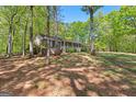 Beautiful home nestled among mature trees, offering a serene and private setting, with a welcoming front porch at 370 Merrydale Dr, Fayetteville, GA 30215
