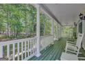 Relaxing covered porch with rocking chairs and views of the surrounding woods at 140 Horton Creek Trl, Brooks, GA 30205