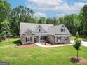 Stunning exterior view of a well-maintained home with lush green lawn and mature trees in the background at 2117 Ella Springs Dr, Covington, GA 30014