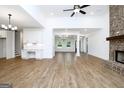 Open-concept living area with a brick fireplace, built-in shelving, and hardwood flooring at 2113 Ella Springs Dr, Covington, GA 30014
