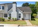 Welcoming townhome exterior with manicured lawn and convenient walkway to the front door at 5882 Trent Walk Dr, Lithonia, GA 30038