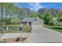 Inviting single-Gathering home with a spacious driveway, lush lawn, and mature trees, perfect for suburban living at 8032 Highland Pkwy, Fairburn, GA 30213