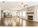 Spacious living room with hardwood floors, a stone fireplace, and plenty of natural light at 1700 Cobblefield Cir, Dacula, GA 30019