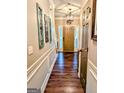 Inviting hallway featuring hardwood floors, elegant wall trim, and a stylish pendant light at 1581 Shetland Pony Nw Ct, Suwanee, GA 30024