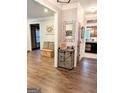 Open-concept living area with hardwood floors, decorative mirror, and seamless flow to the kitchen at 1581 Shetland Pony Nw Ct, Suwanee, GA 30024