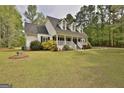 Angled view of a charming home featuring dormer windows and a well-maintained lawn and landscaping at 225 Mapledale Trl, Sharpsburg, GA 30277