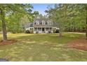 Spacious front yard showcasing a well-maintained lawn and mature trees surrounding the home at 225 Mapledale Trl, Sharpsburg, GA 30277