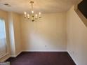 A dining room with neutral walls, carpet flooring, and a brass chandelier at 2337 Carousel Park Dr, Morrow, GA 30260