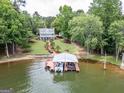 Panoramic aerial view showcases a beautiful lakeside home with private dock, lush green lawn, and mature trees for privacy at 270 Polk Rd, Covington, GA 30014