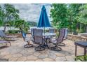 This backyard stone patio with an umbrella offers a cozy outdoor seating area, perfect for enjoying the beautiful surroundings at 270 Polk Rd, Covington, GA 30014