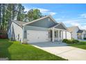 Charming home showcasing a two-car garage, covered porch, and green lawn at 790 Riverwood Pass, Dallas, GA 30157