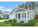 Charming blue home featuring a covered porch, manicured lawn, and white trim at 790 Riverwood Pass, Dallas, GA 30157